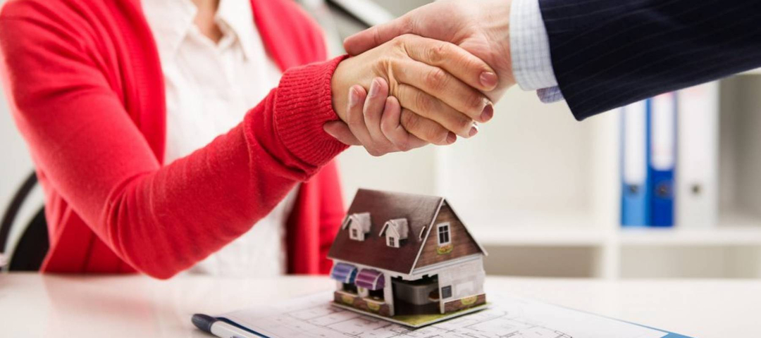 Woman shakes hands as she closes on a home.