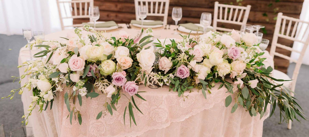 Wedding floral table decoration with candles in transparent vases