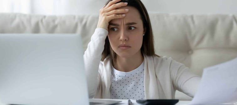 Confused young woman calculating household expenses, have problems paying bills online