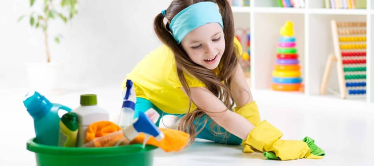 Cute child little girl cleanses a floor in nursery at home