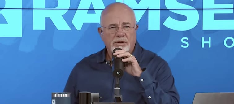 Dave Ramsey speaks into a microphone on set of his talk show.