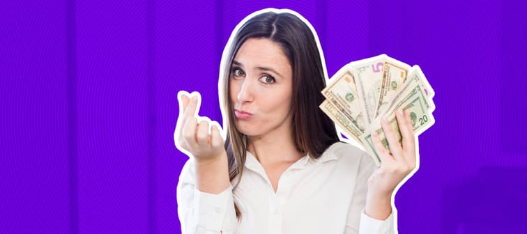 woman holding a fan of dollar bills in one hand