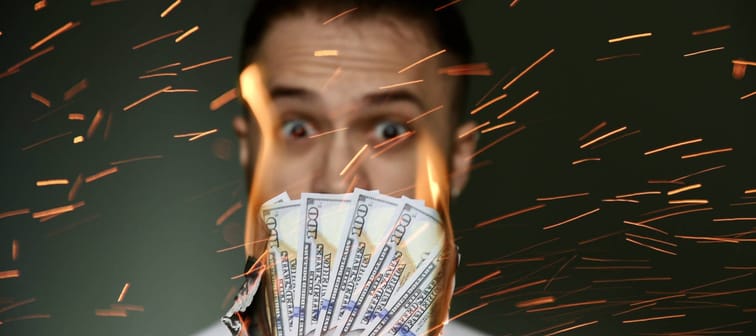 A person watches cash burn.