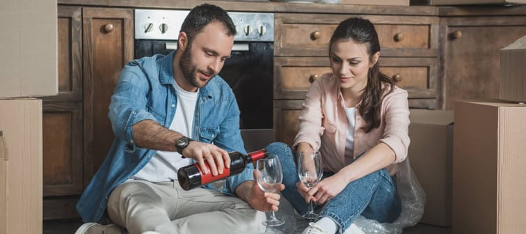 A couple drinks wine after moving into their new home.