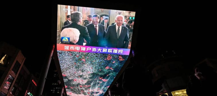 An outdoor screen in Beijing shows a news program about Chinese President Xi Jinping meeting US President Joe Biden.