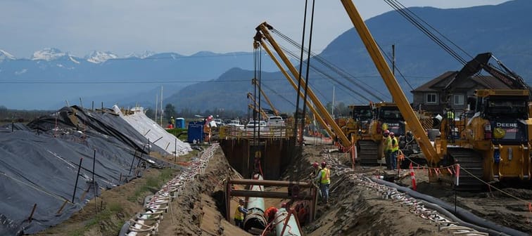 Workers lay pipe during construction of the Trans Mountain pipeline expansion on farmland, in Abbotsford, B.C., on Wednesday, May 3, 2023. Wednesday marks the official start date of the long-