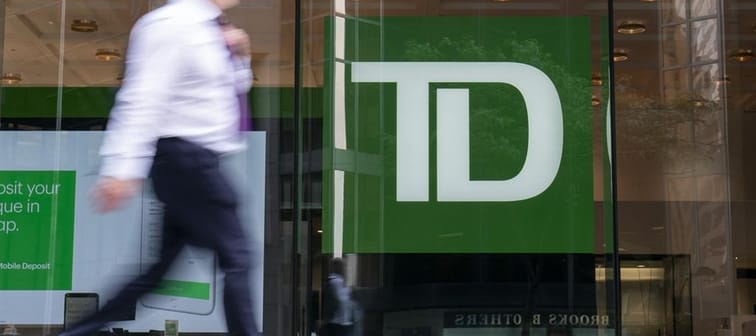 A person makes their way past a Toronto-Dominion Bank in the Financial District of Toronto on August 14, 2023. 