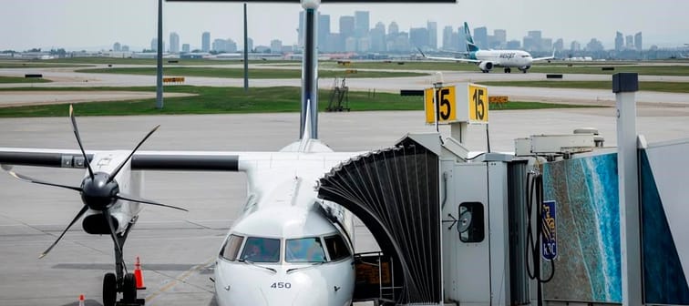 A WestJet passenger jet taxis while a WestJet turbo prop plane sits parked at a departure gate at the Calgary International Airport on Wednesday, May 31, 2023. A statement from the Calgary-ba