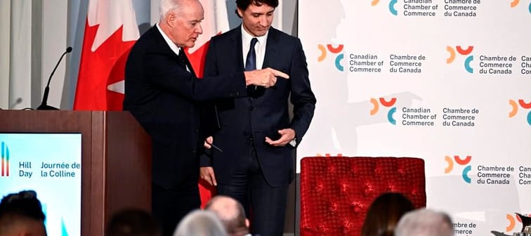 Perrin Beatty, president of the Canadian Chamber of Commerce, points Prime Minister Justin Trudeau to his seat for a fireside discussion, after Trudeau's remarks at the Canadian Chamber of Co