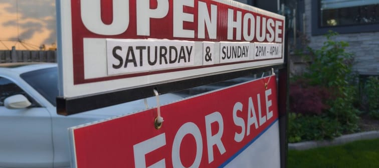Sign for sale open house in front of detached house in residential area.