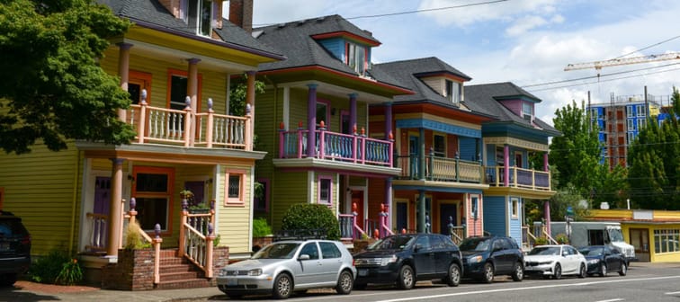 Cars are parked in front of historic houses in Portland