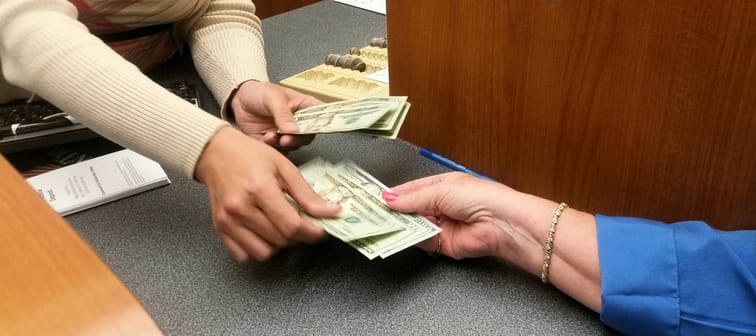 Bank teller giving money to a customer.