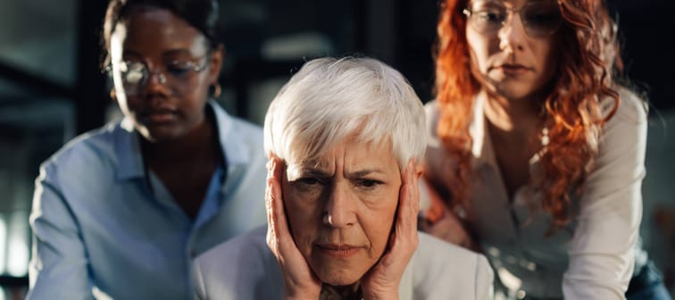 Three women looking on anxiously.