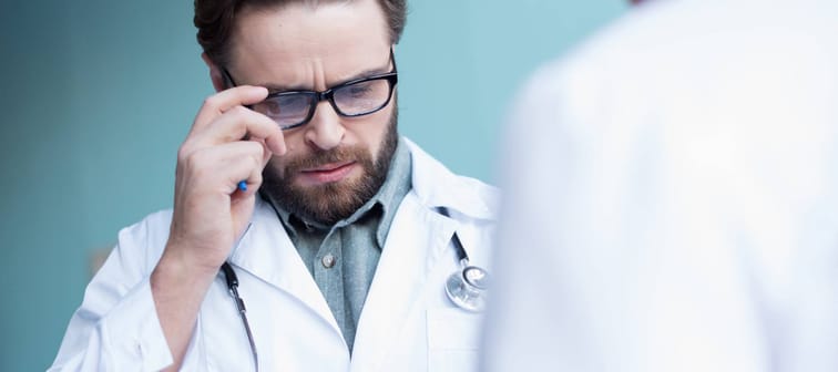 A doctor looks over the documentation of a patient.