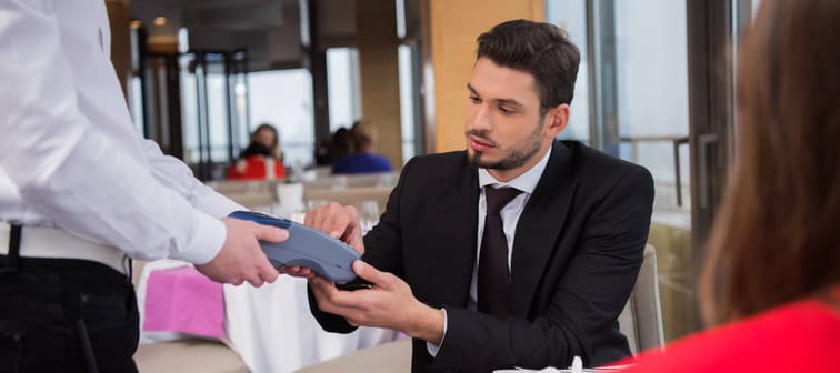 Young man paying restaurant bill.