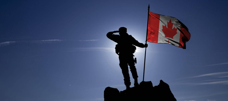 Soldier on top of the mountain with the Canadian flag