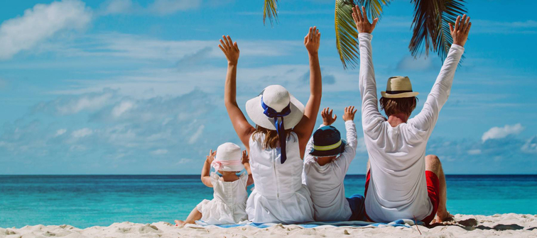 happy family with two kids hands up on the beach