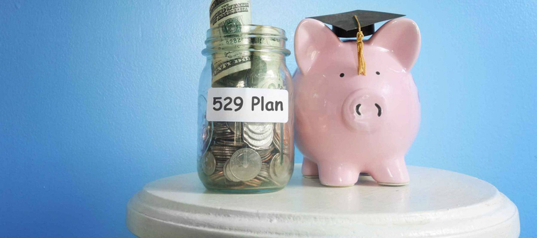 Piggy bank with graduation cap and 529 Plan coin jar -- college savings plan concept