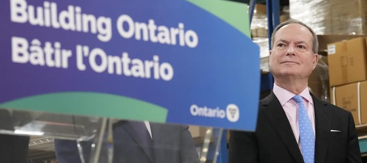 Ontario Finance Minister Peter Bethlenfalvy listens to Ontario Premier Doug Ford speak after touring the Oakville Stamping and Bending Limited facility in Oakville, Ont., on Wednesday, March 