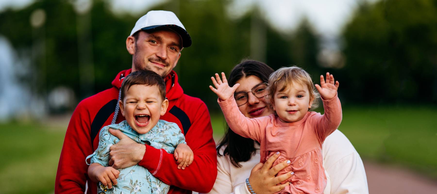 Family portrait of mother and father with toddler siblings outdoors