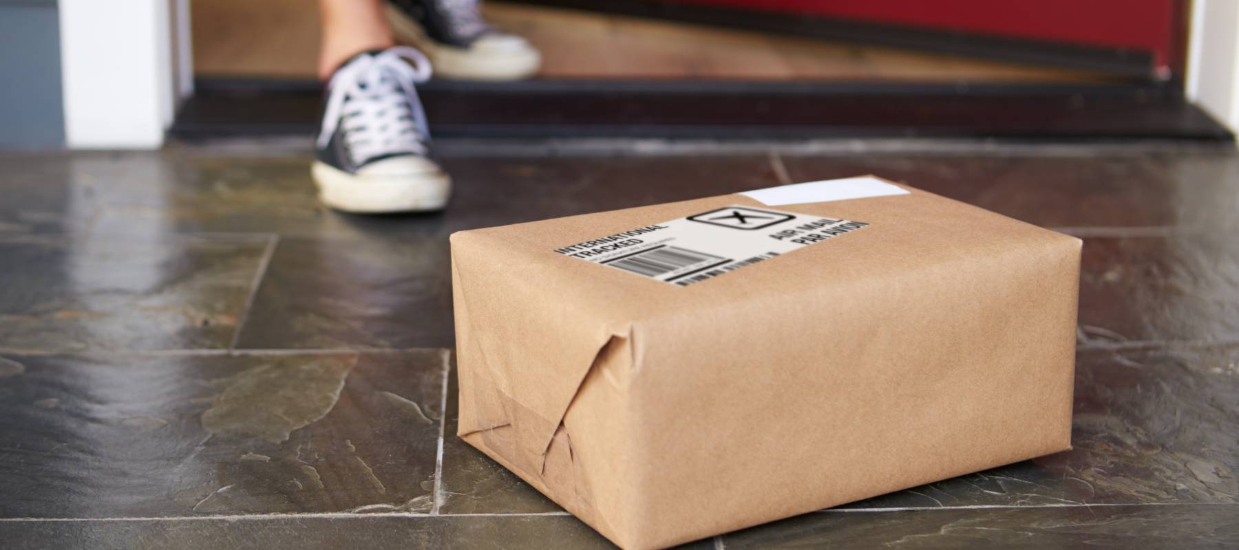 Man picking up a package from his porch.