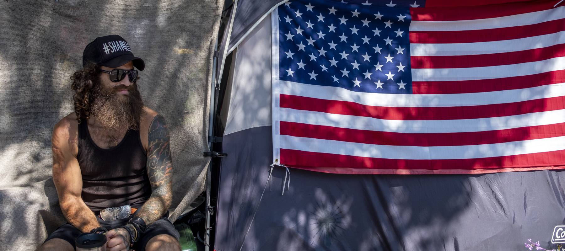 Jonathan Garcia sits next to his tent in a homeless encampment outside the West L.A. Veterans Affairs campus in Los Angeles, Aug. 30, 2021.