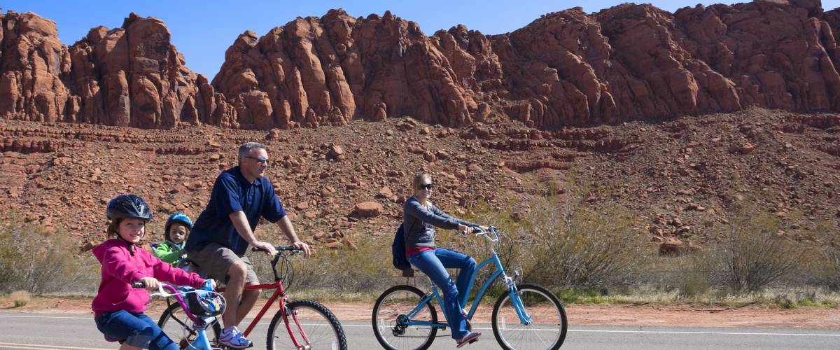 Family bike riding with red rocks in background
