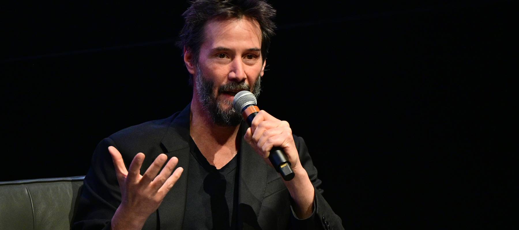 Keanu Reeves speaking at an event.