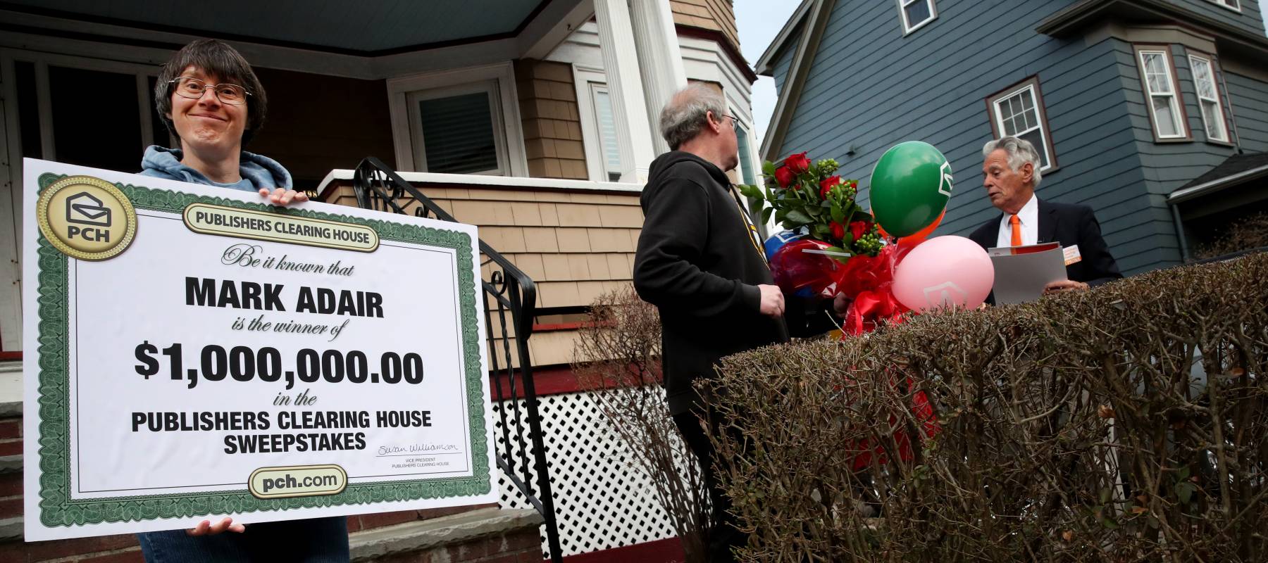 Sara Adair shows off the oversized check for 1 million dollars her husband Mark received from Dave Sayer of the Publishers Clearing House Prize Patrol in South Boston, MA on April 01, 2022.