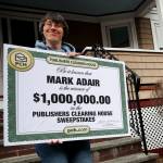 Sara Adair shows off the oversized check for 1 million dollars her husband Mark received from Dave Sayer of the Publishers Clearing House Prize Patrol in South Boston, MA on April 01, 2022.