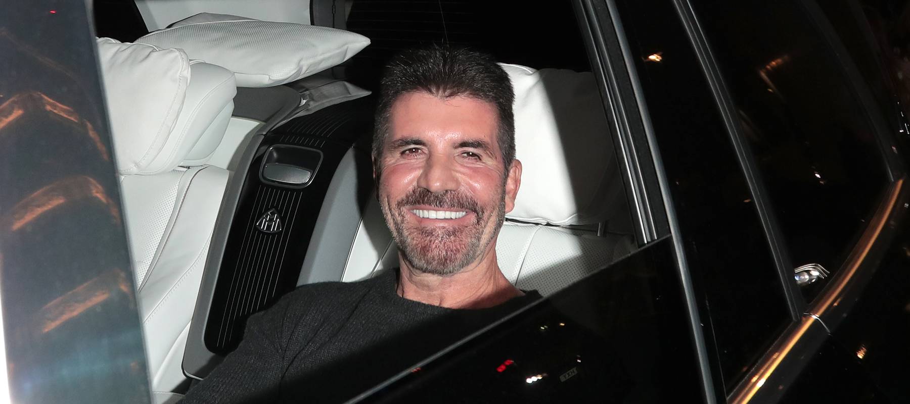 Simon Cowell in the back of a car.