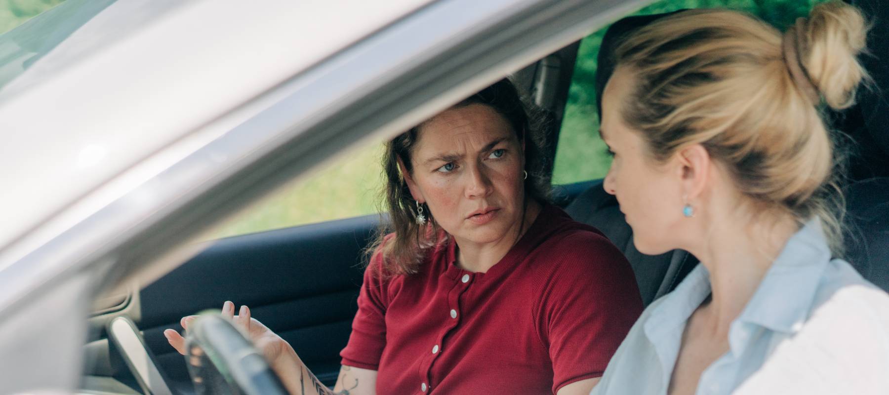 Two upset female travelers in a car