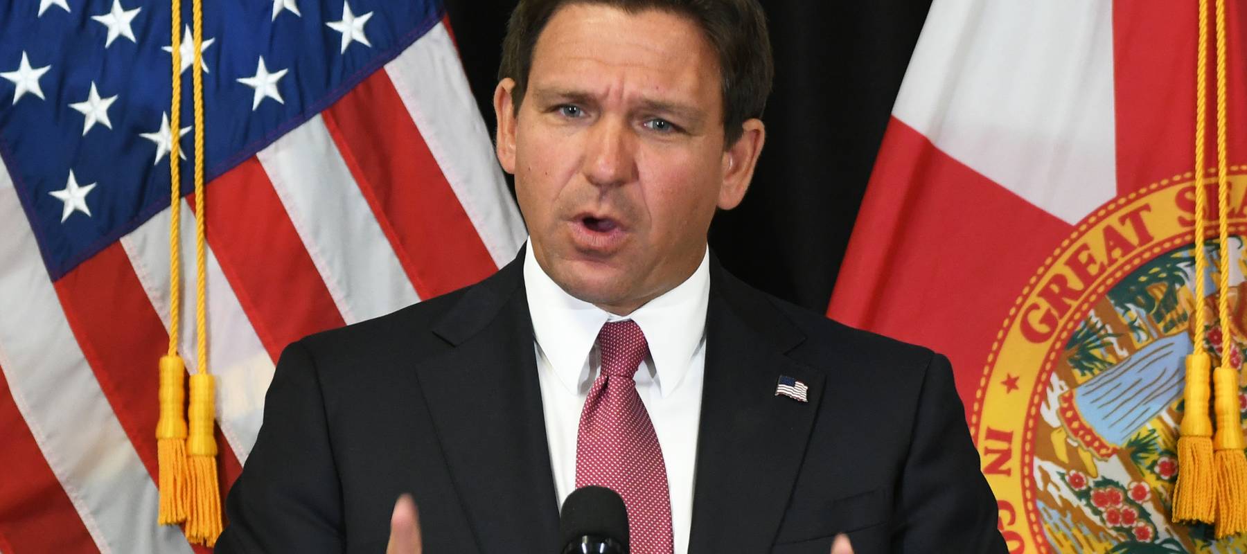 Ron DeSantis speaks at a podium.