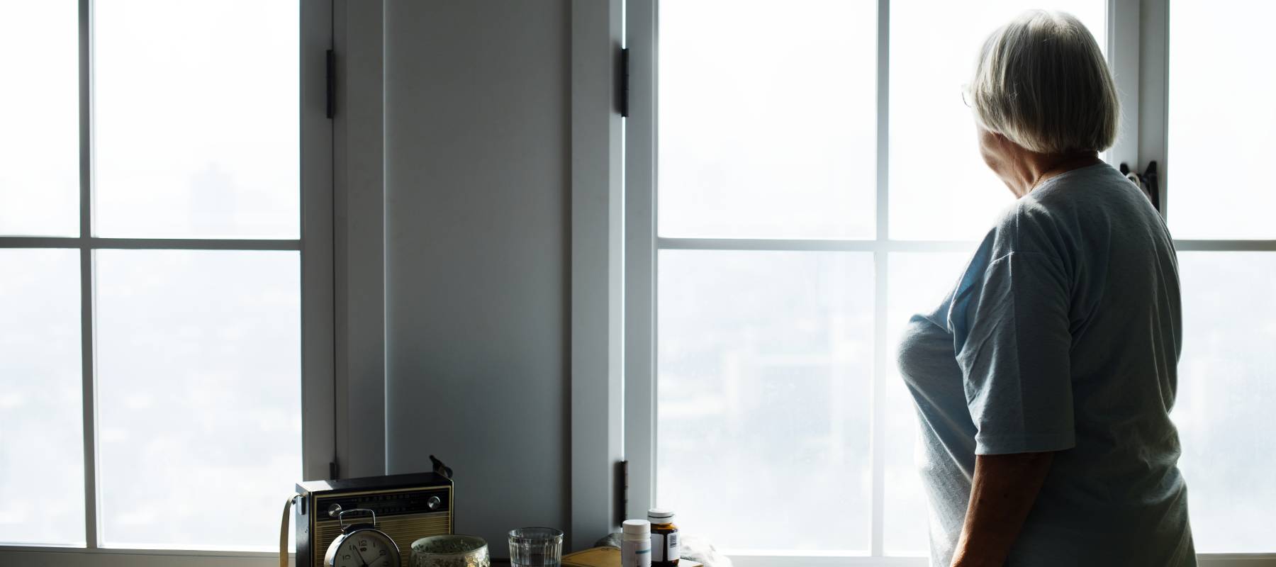 Elderly woman looking out the window