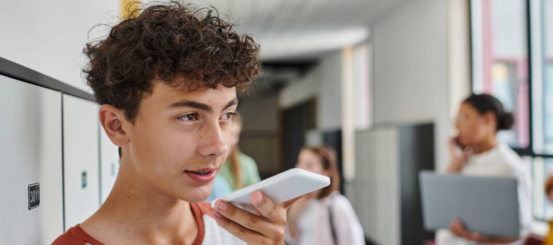 Teen boy talking into smartphone