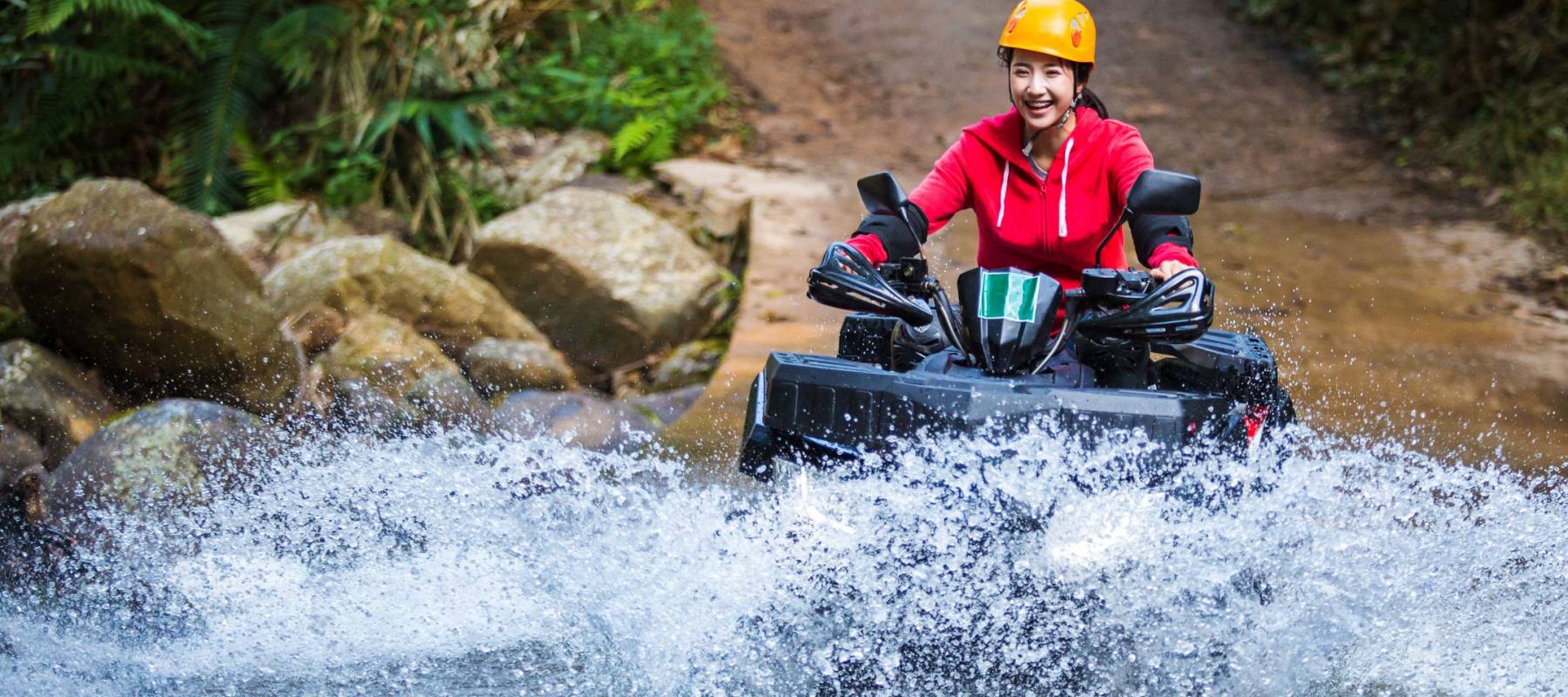 The girl driving an ATV through the river Spree.