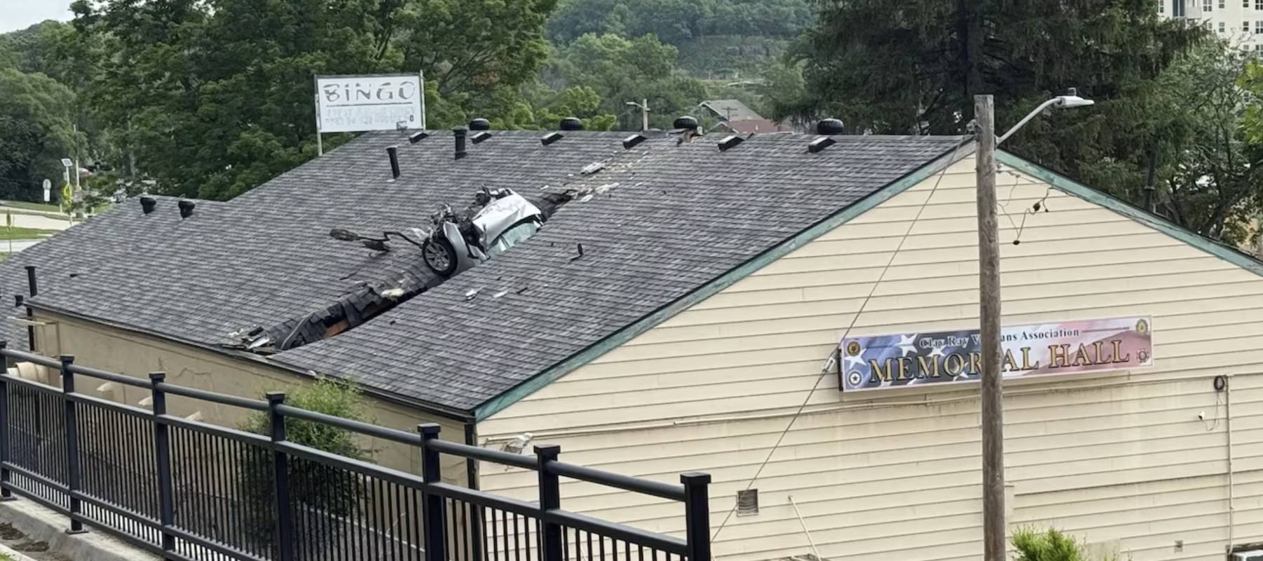 Image of a car crashed into a roof of a veterans' building.