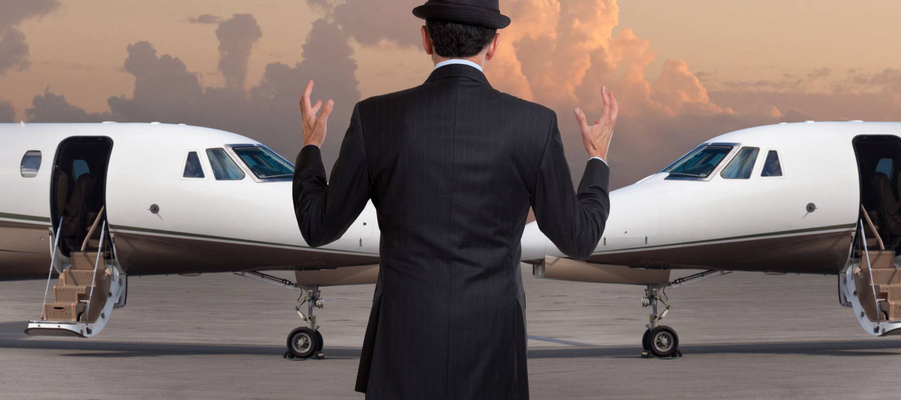 Business man in front of two private jets