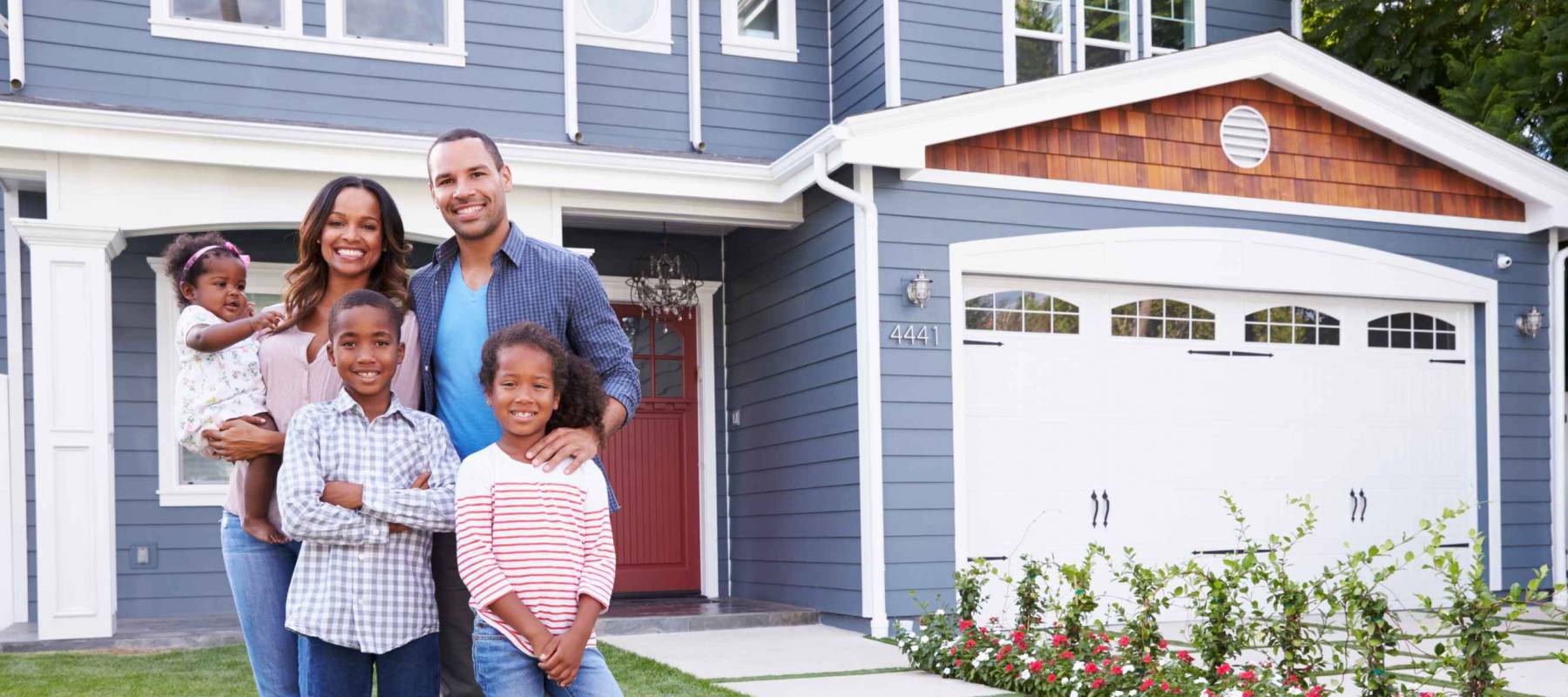 Happy black family standing outside their house