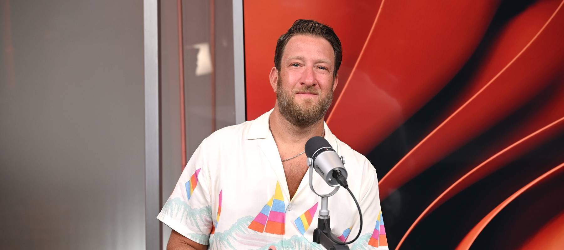 Dave Portnoy sitting at desk with microphone.