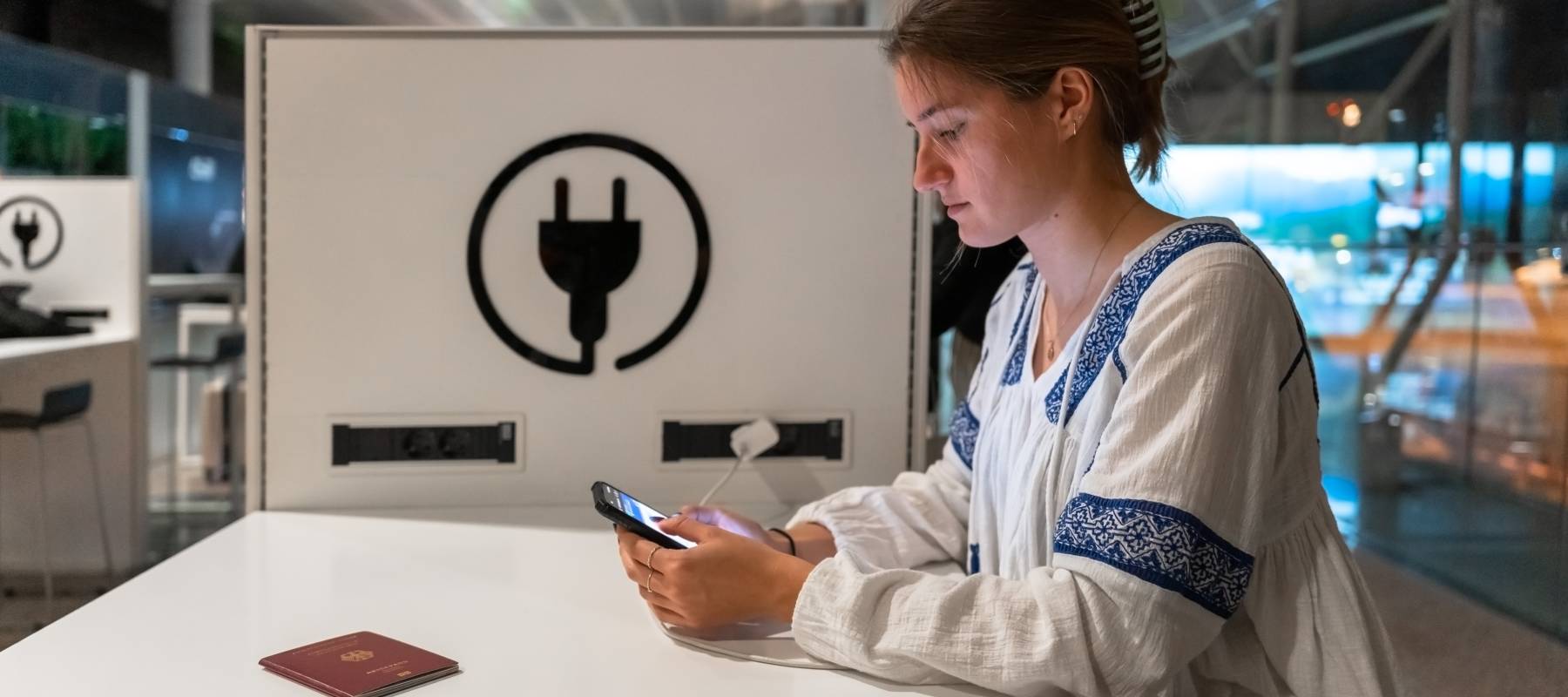 Woman charging her phone in the airport
