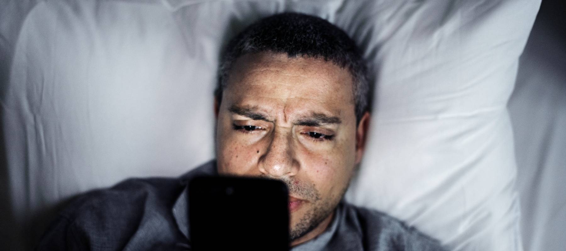 Man in bed on his smartphone.