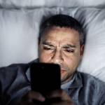 Man in bed on his smartphone.