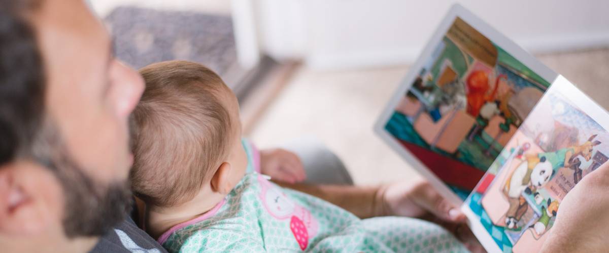 Father reading a book to his infant child