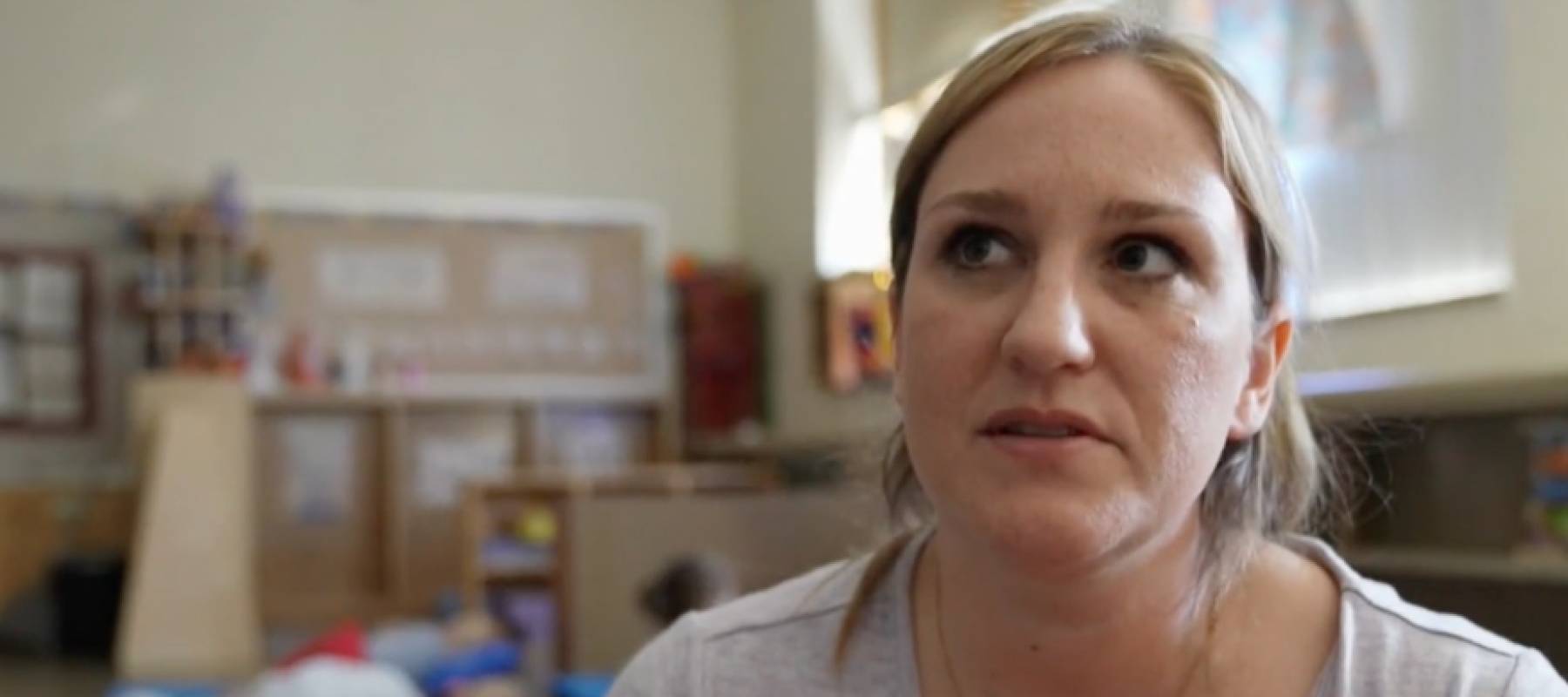 Woman speaking on camera in a classroom.