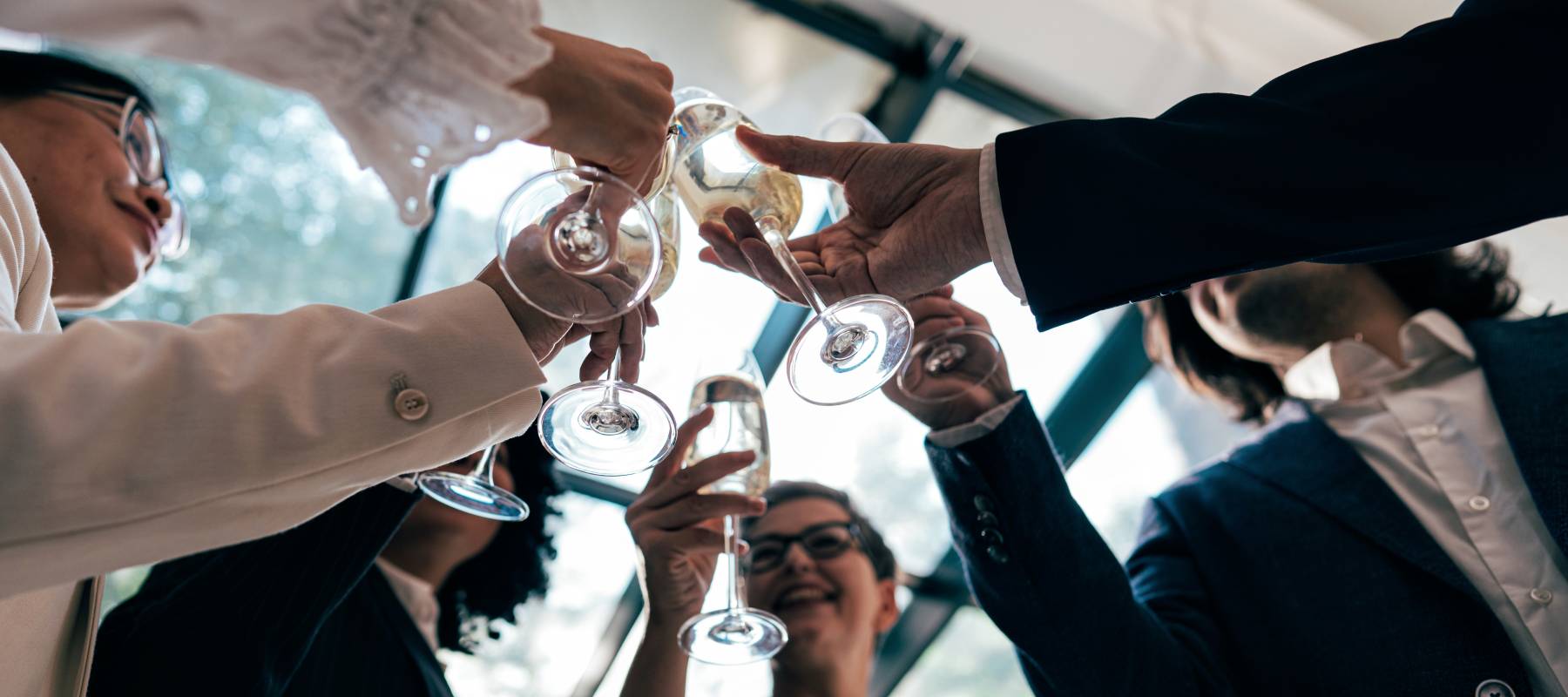 A group of wealthy people clink glasses to celebrate reaching the millionaire's club.