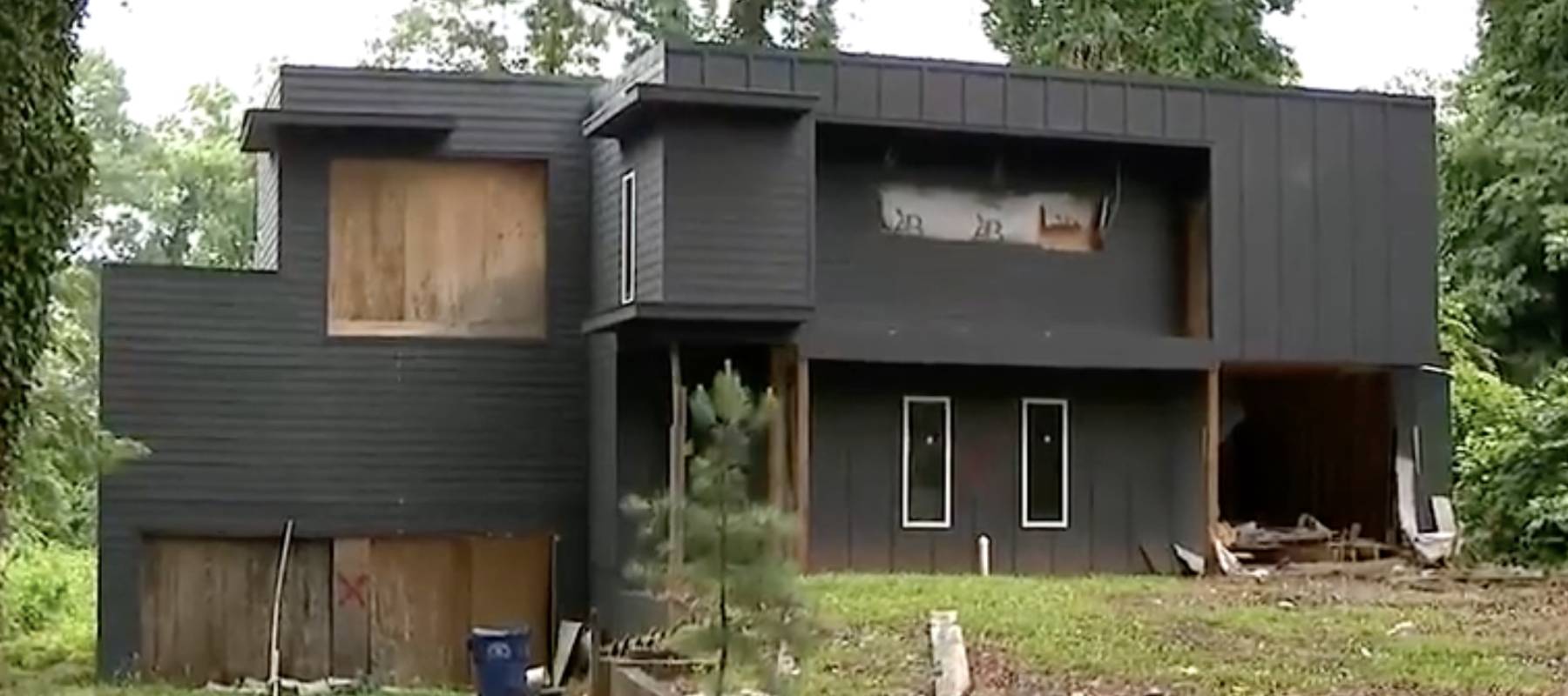 Exterior view of Ronaldo Norman's home with hole in one of the walls on the lower floor.