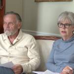 Man and woman sitting on a couch on camera.