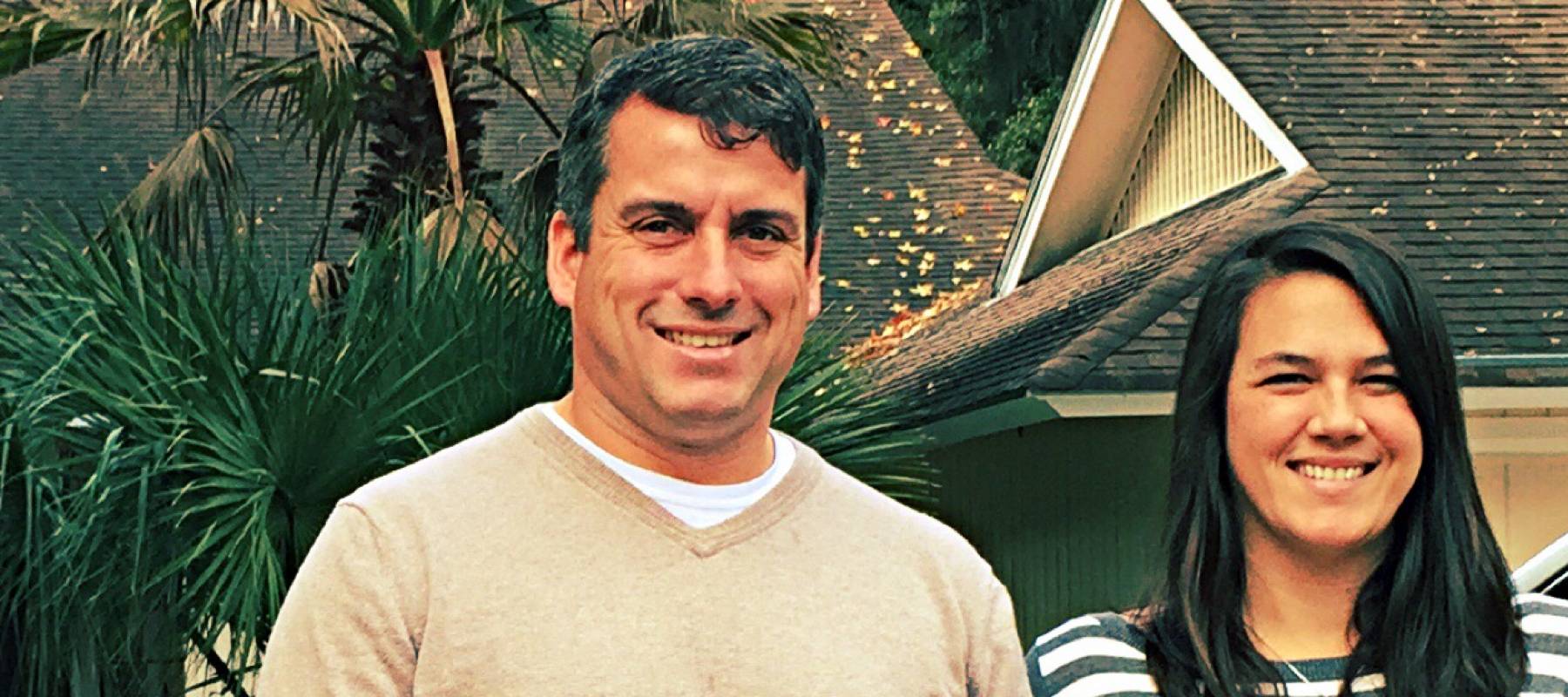 Couple in front of home in tropical area