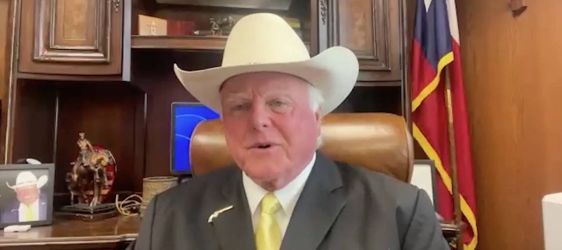 Texas Agriculture Commissioner Sid Miller in his office with Texas flag in background.